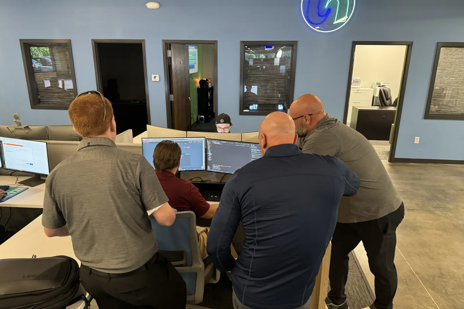 Four ThrottleNet technicians working through a problem around one workstation