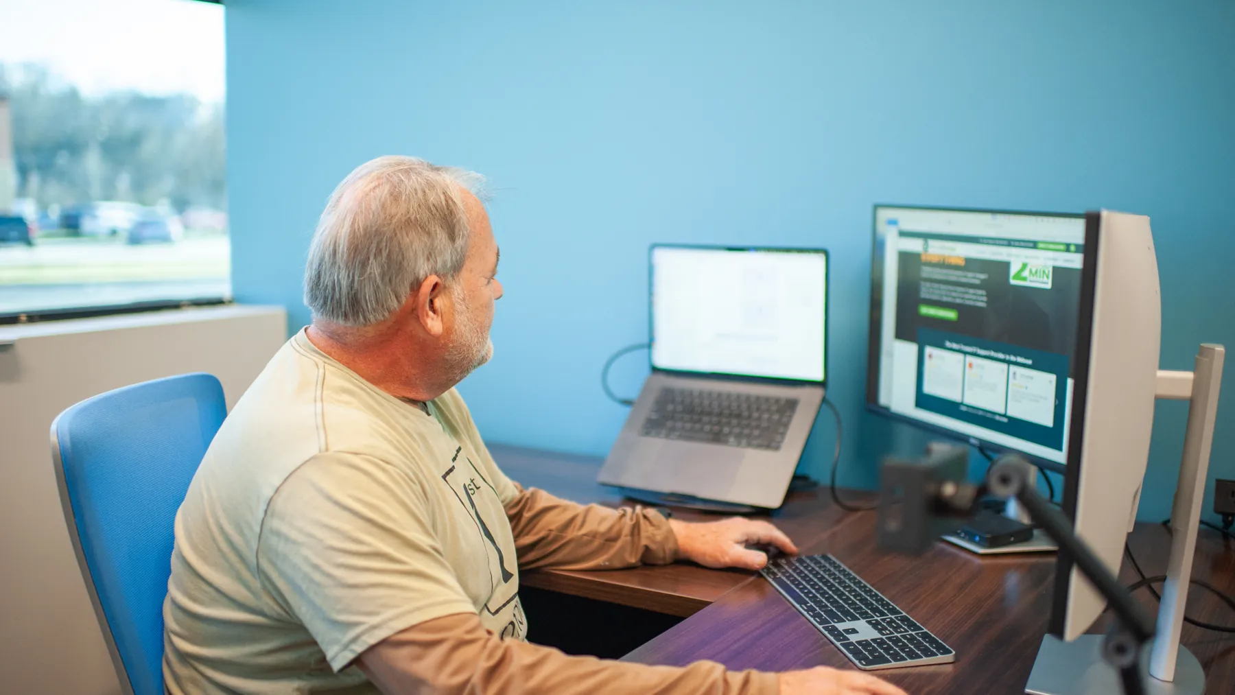 A ThrottleNet engineer reviewing a mailbox and admin console across a laptop and two monitors